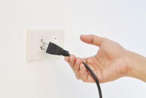 puxando a tomada de energia elétrica